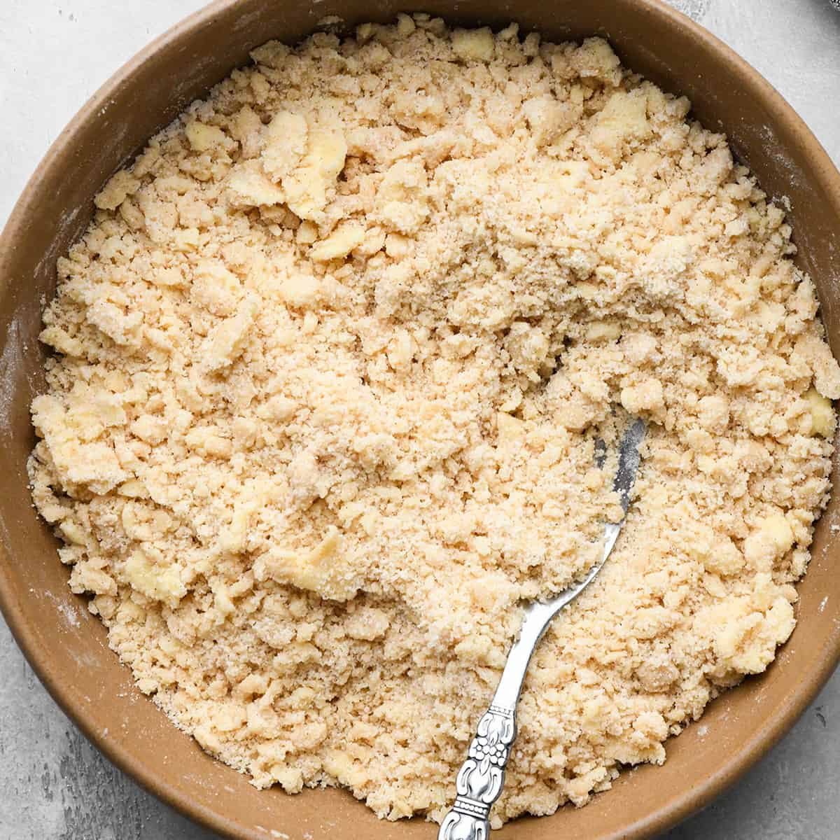 apple crumble pie topping in a bowl with a fork