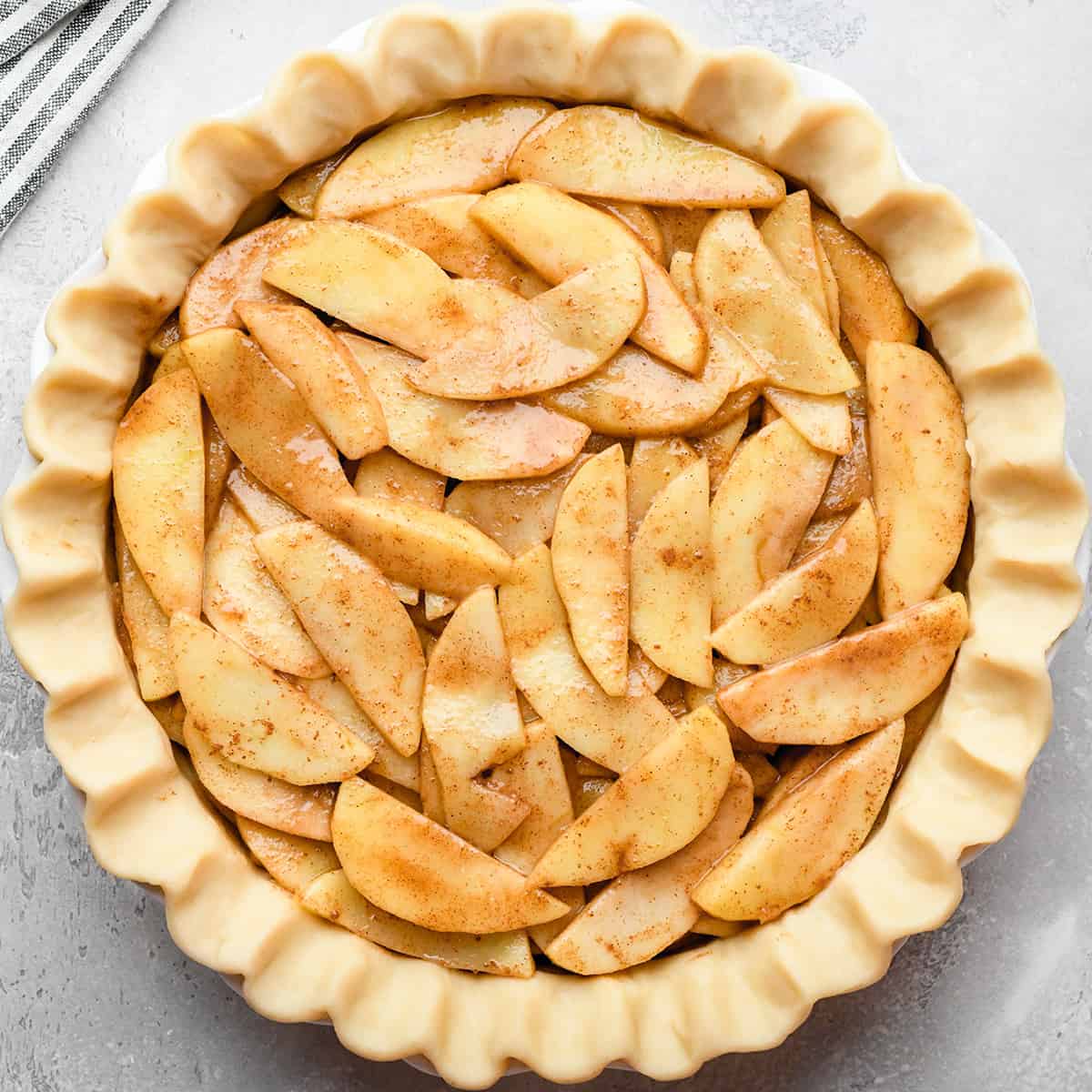 assembling apple crumb pie - putting filling in a pie crust