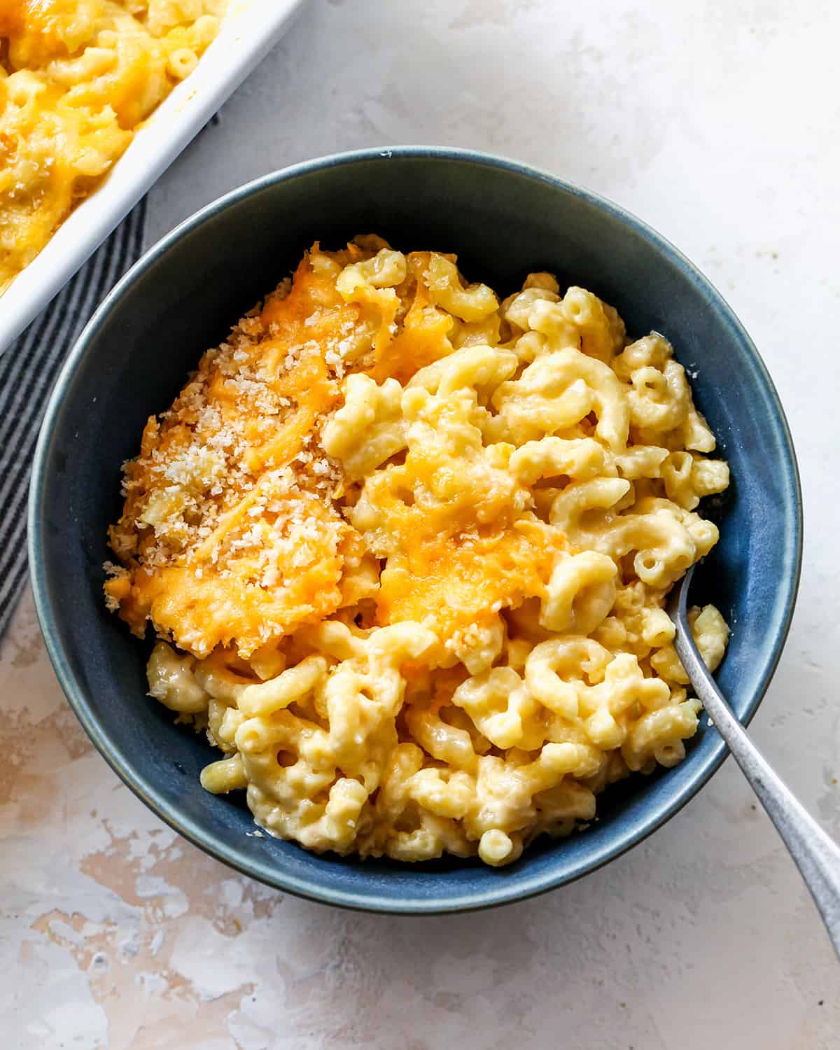 Baked Mac and Cheese in a blue bowl with a spoon