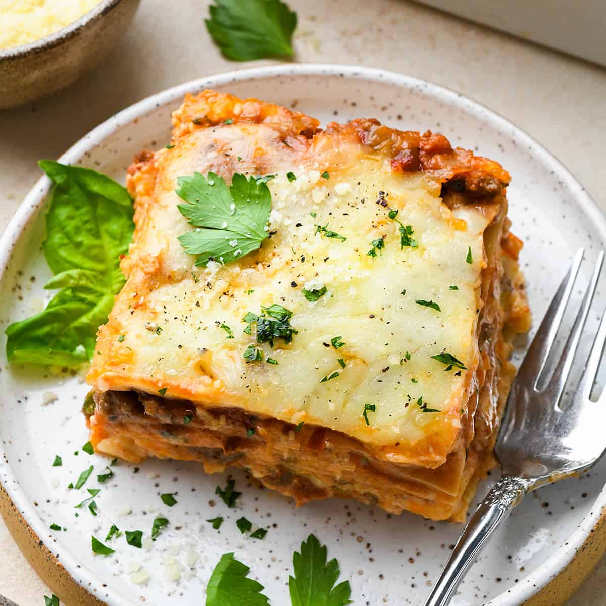 a piece of Meat Lasagna on a plate with a fork