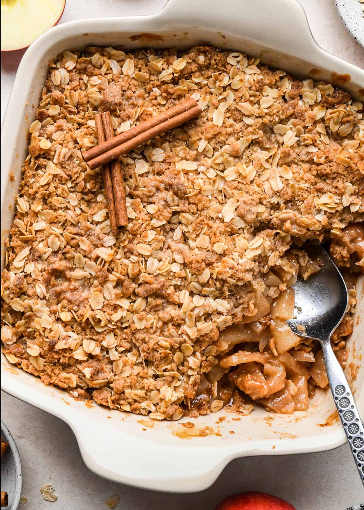 Apple Crisp in a baking dish with a spoon scooping some out to serve