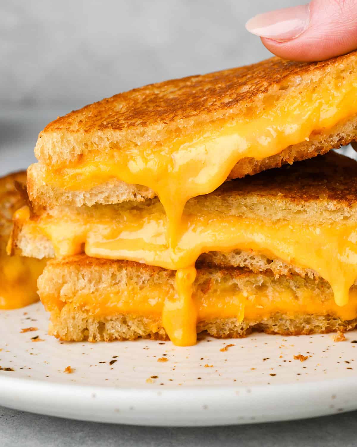 three halves of grilled cheese sandwiches stacked on each other 