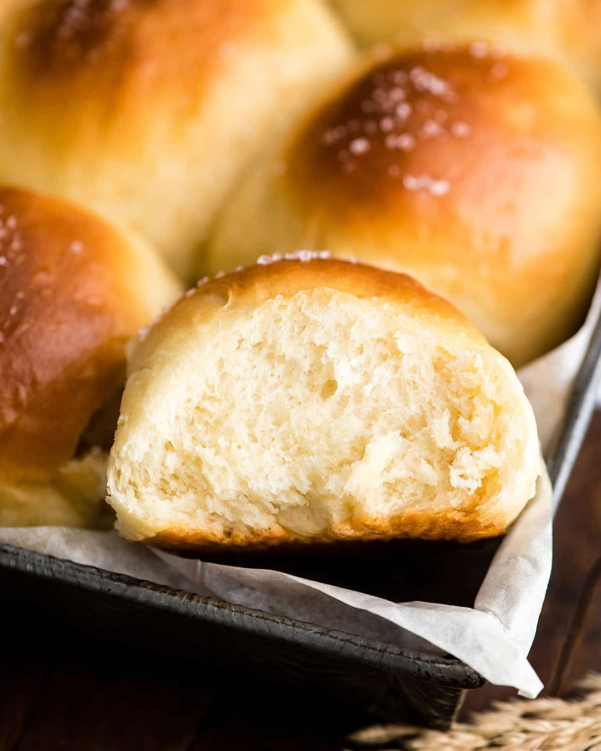 up close overhead view of a Homemade Dinner Roll in the pan with other rolls surrounding it after baking