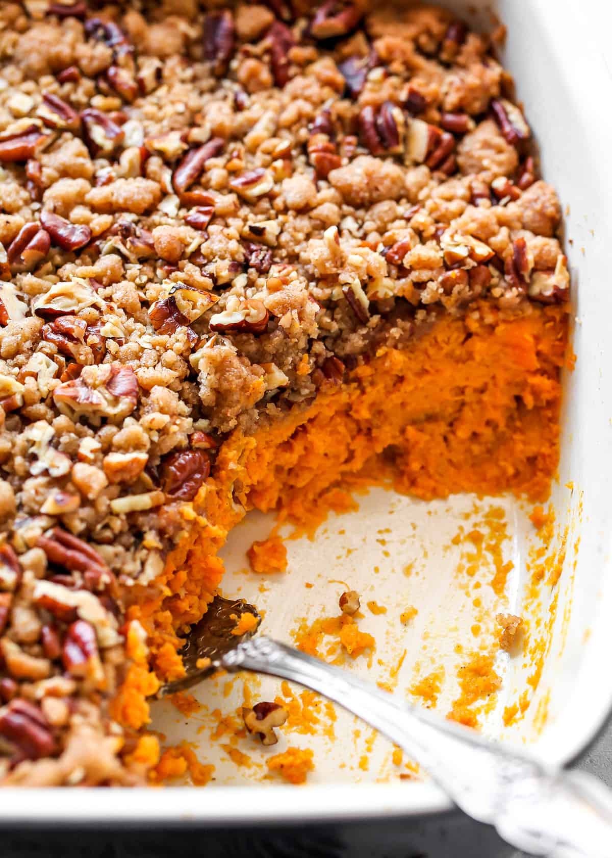 sweet potato casserole in a baking dish with a serving spoon