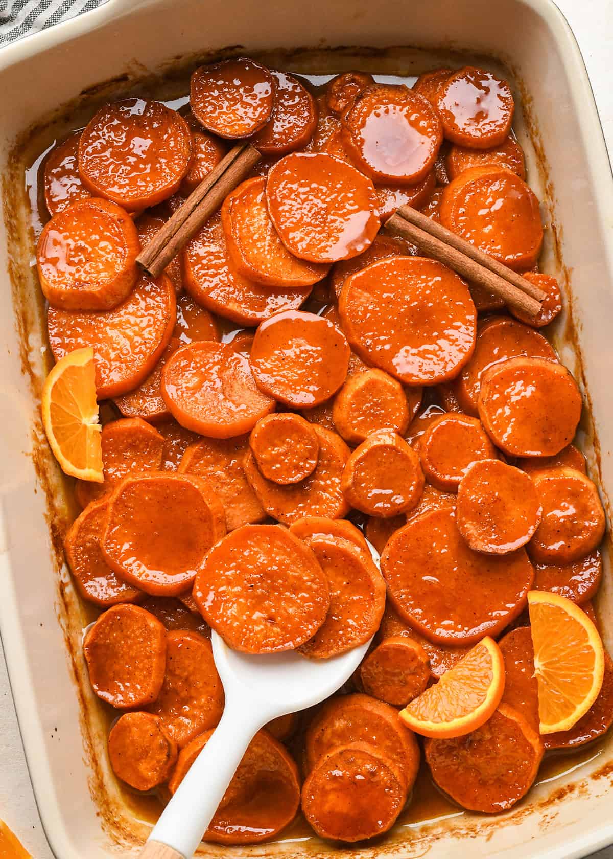 Candied Yams in a baking dish with a spoon