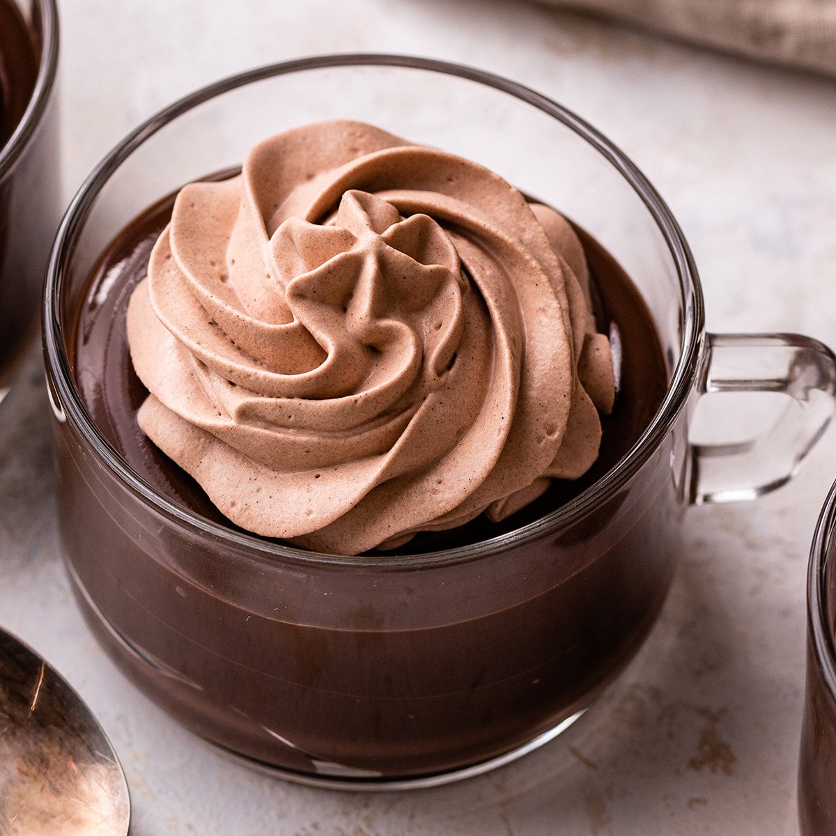 Chocolate Whipped Cream on top of chocolate pudding in a glass cup