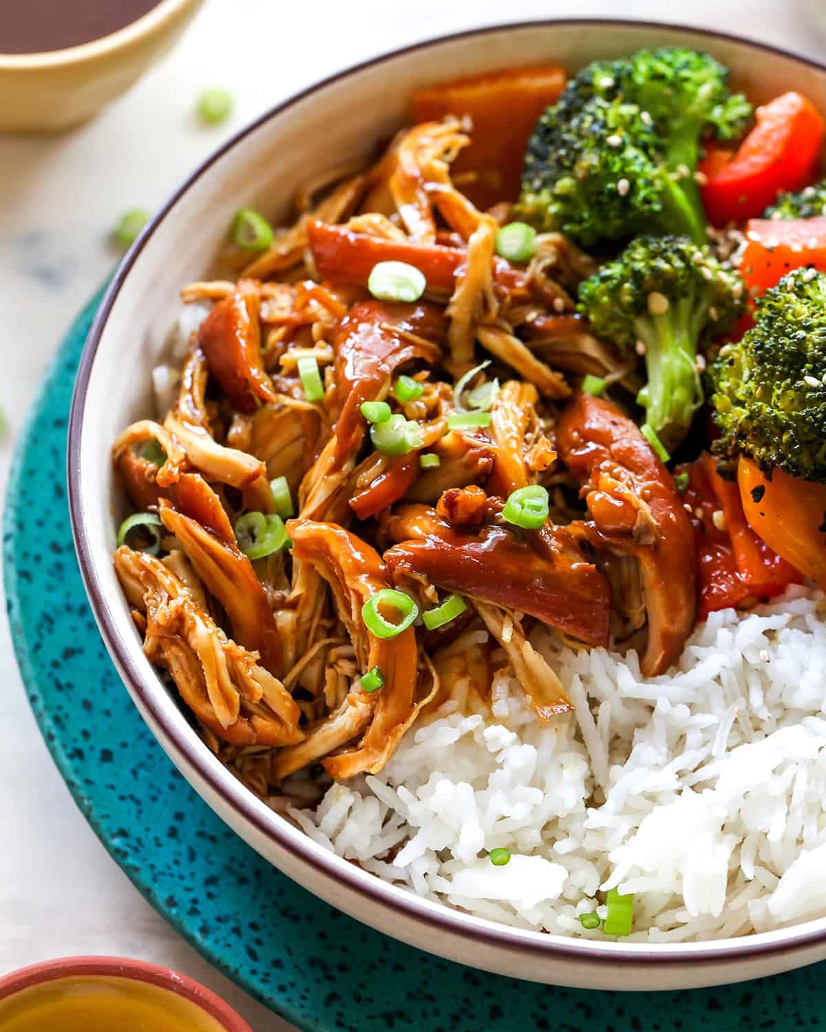 up close front view of a bowl of crockpot teriyaki chicken with veggies and rice