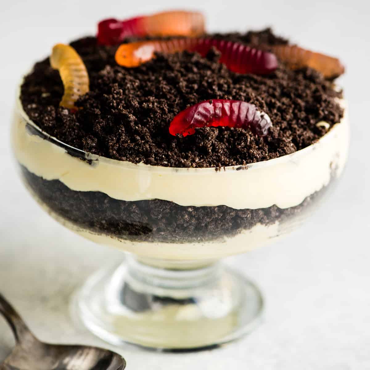 dirt pudding in a small individual serving dish with gummy worms on top