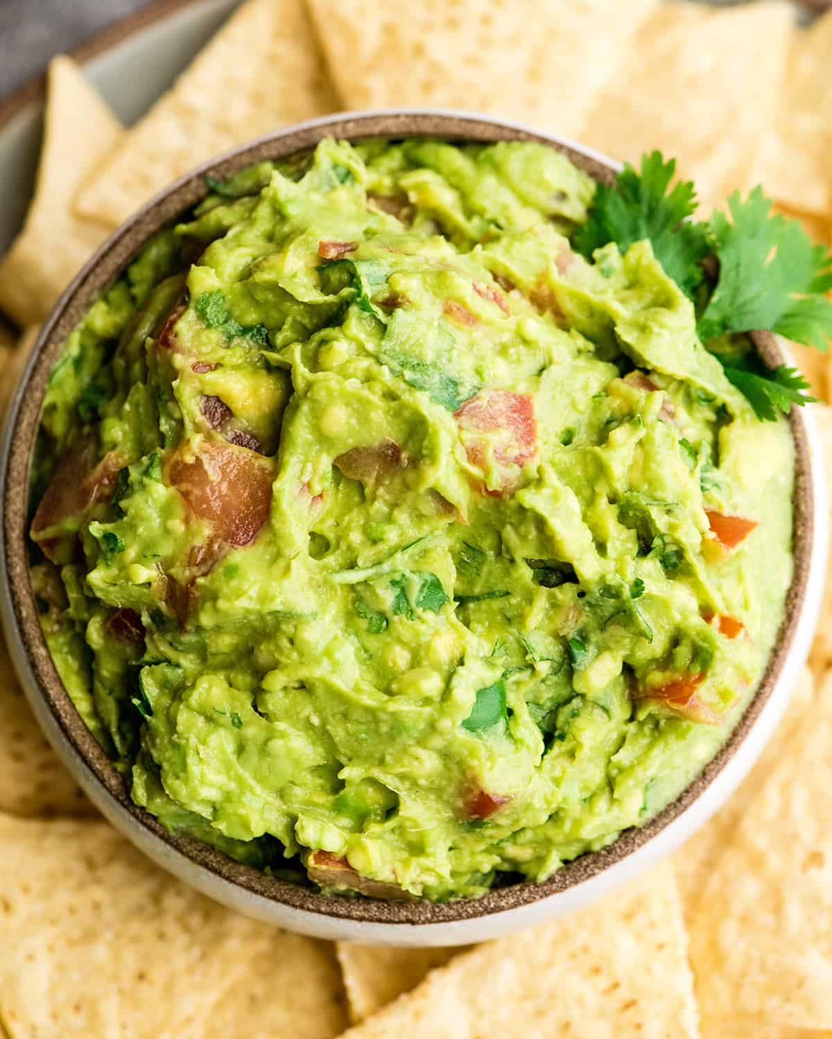 Overhead view of easy guacamole recipe in a bowl surrounded by chips