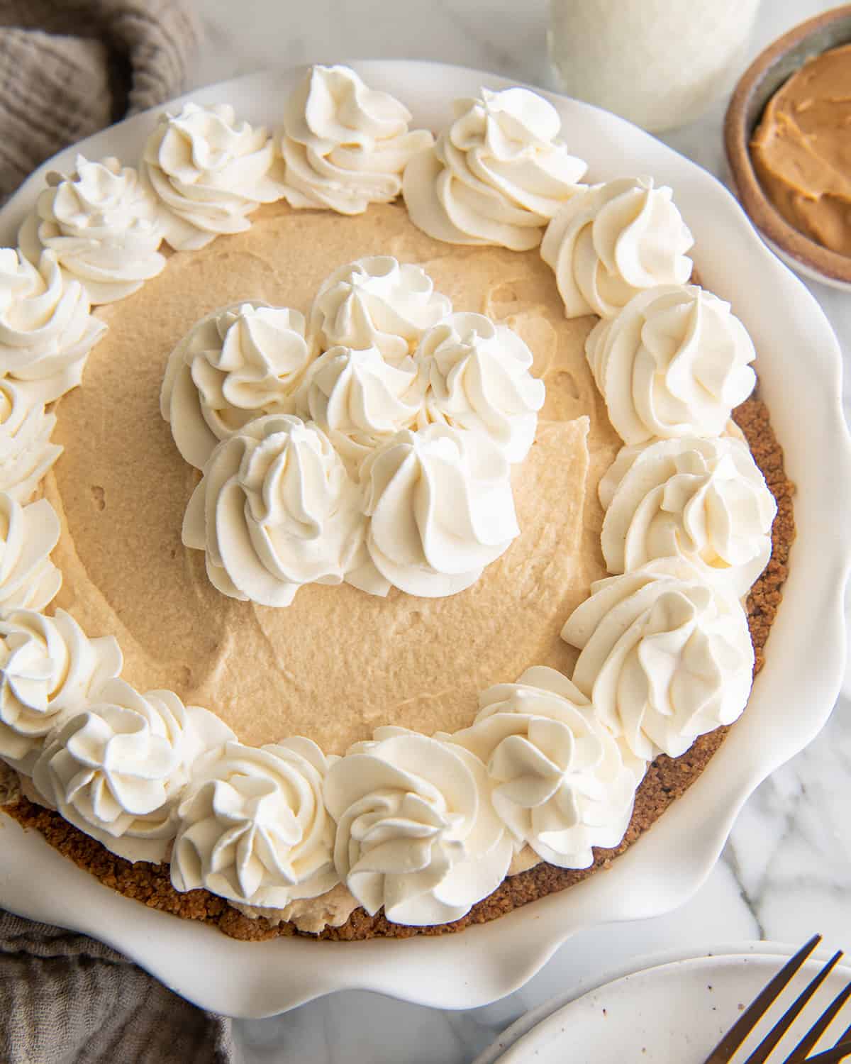 Peanut Butter Pie in a pie dish decorated with whipped cream