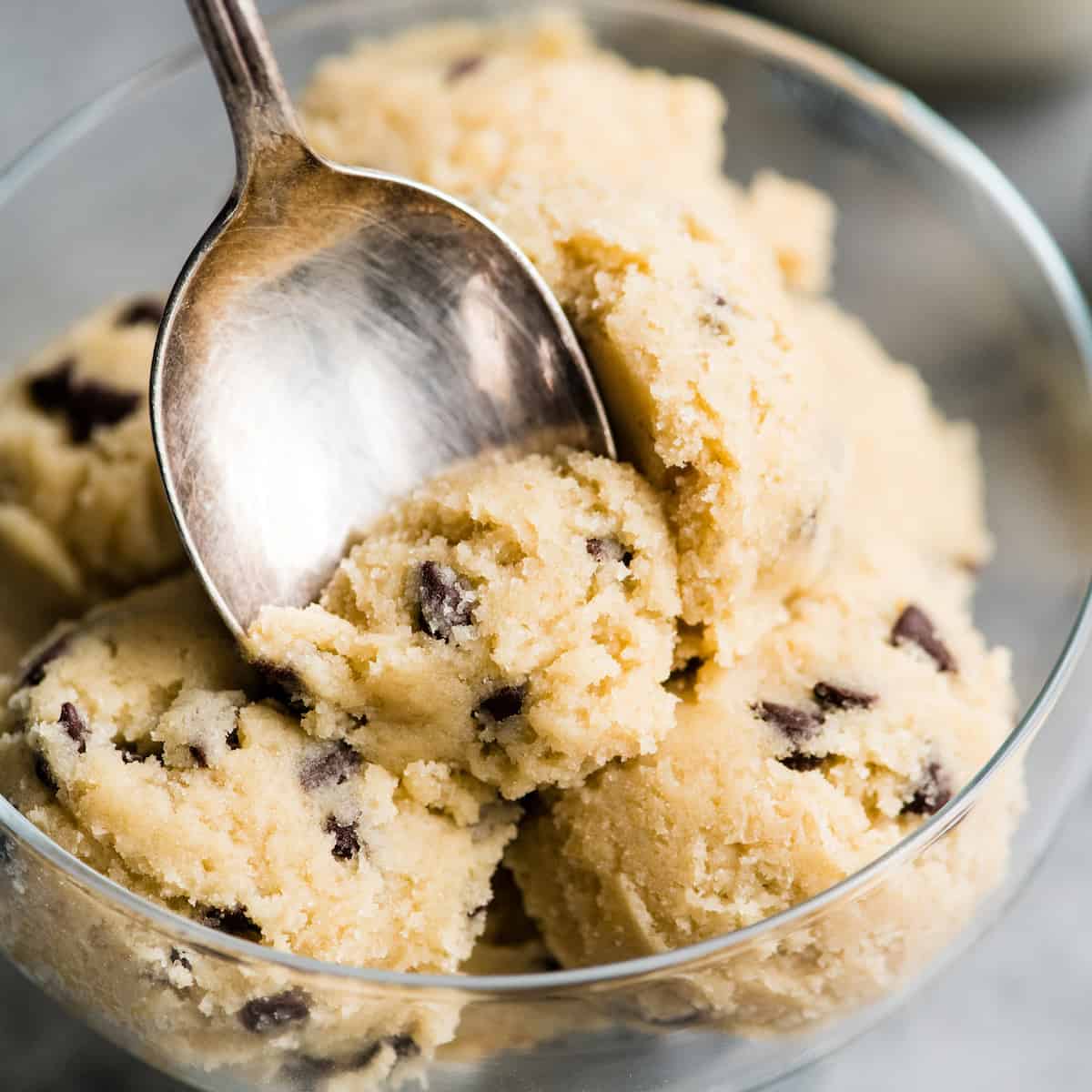 overhead view of a spoon taking a scoop of Edible Cookie Dough out of a glass dish