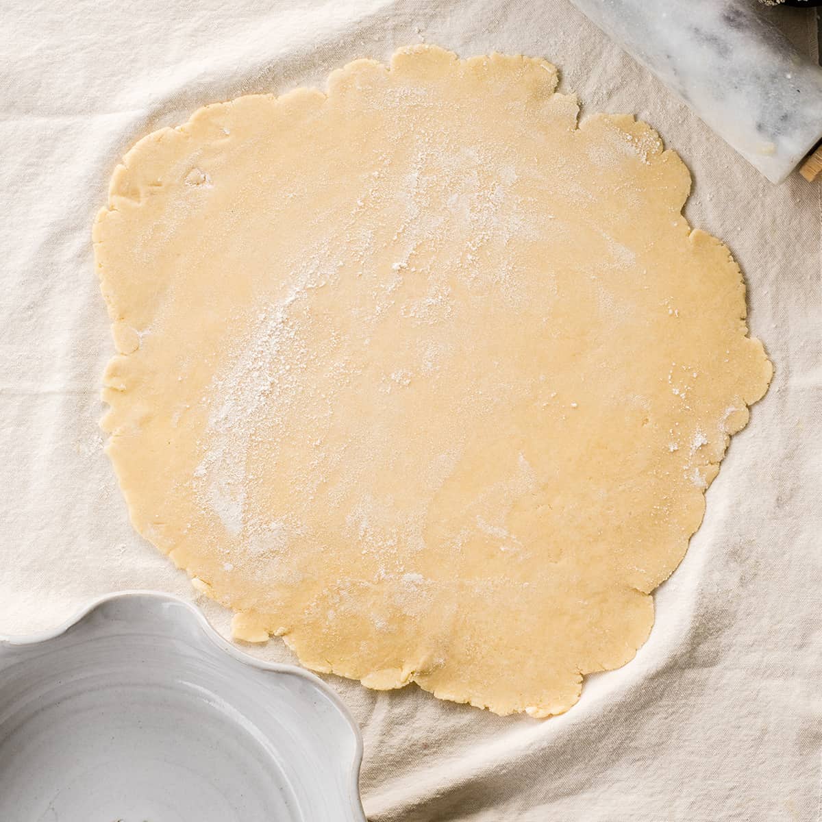 overhead photo of a butter pie crust rolled out onto a pastry cloth