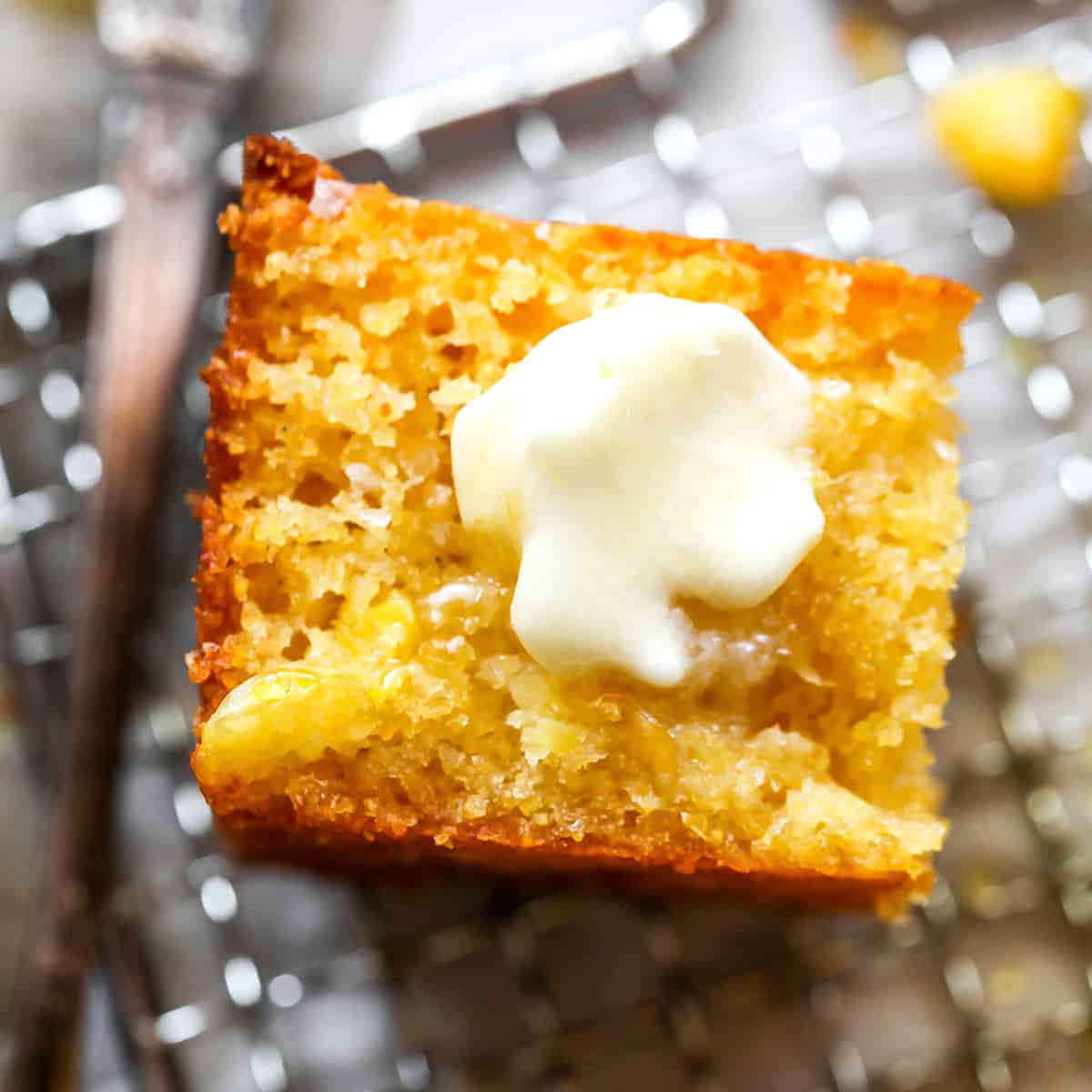 a piece of homemade cornbread with melting butter on top