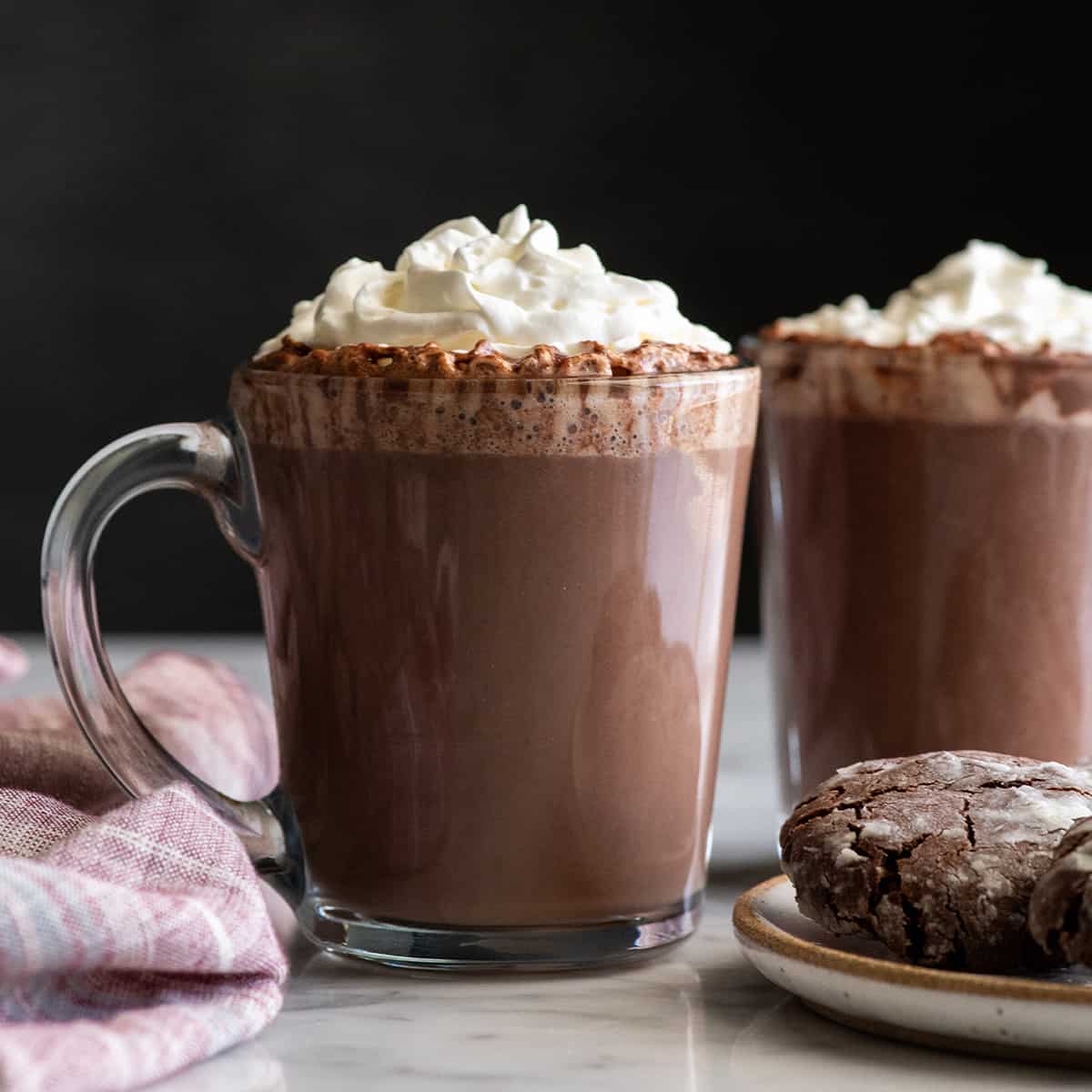 front photo of a glass mug of homemade hot chocolate with whipped cream