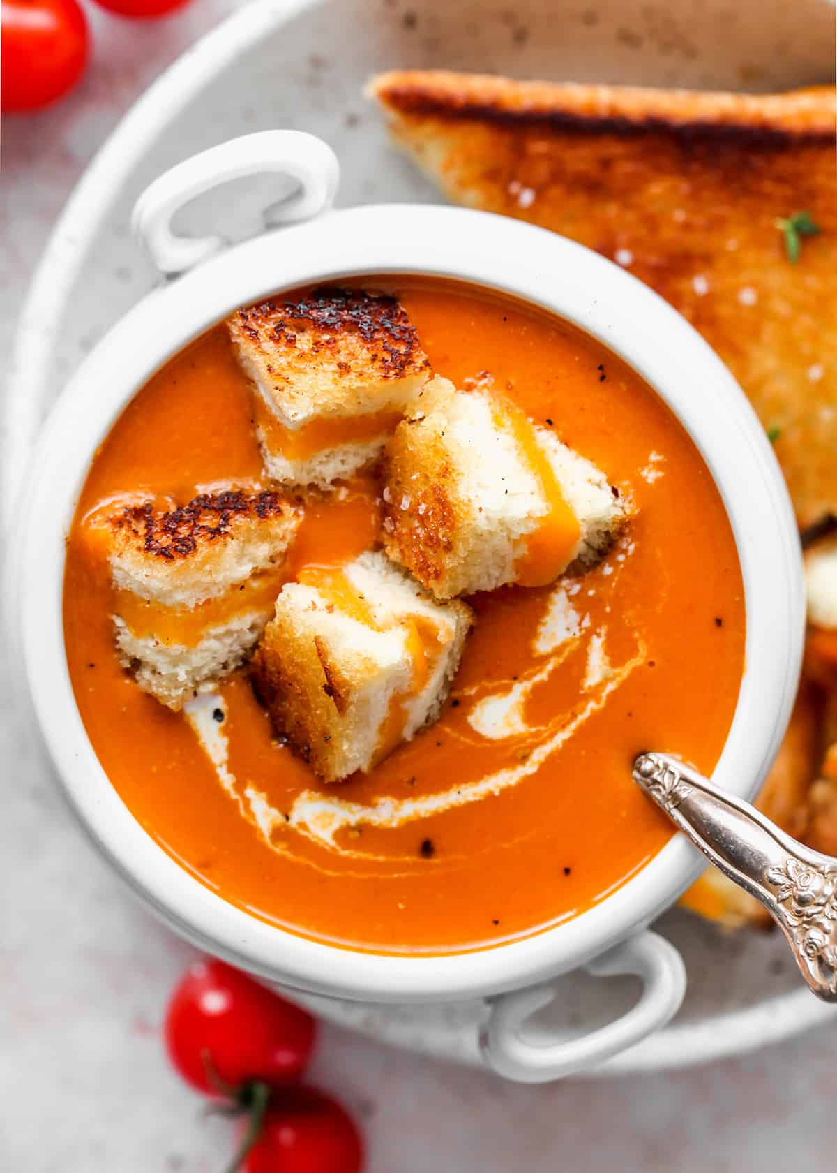 a bowl of Homemade Tomato Soup with grilled cheese cut up in the soup