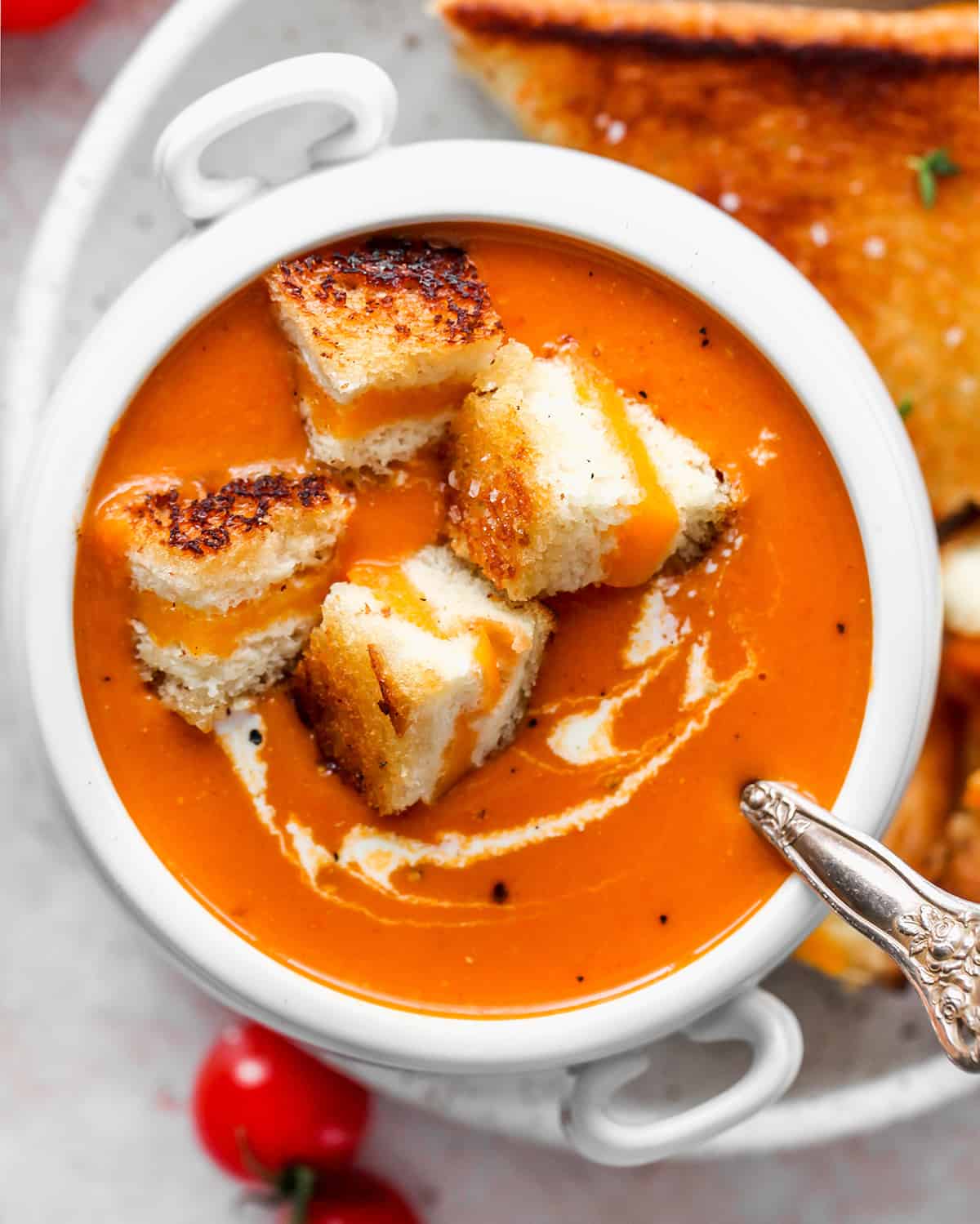 bowl of Homemade Tomato Soup with grilled cheese pieces inside