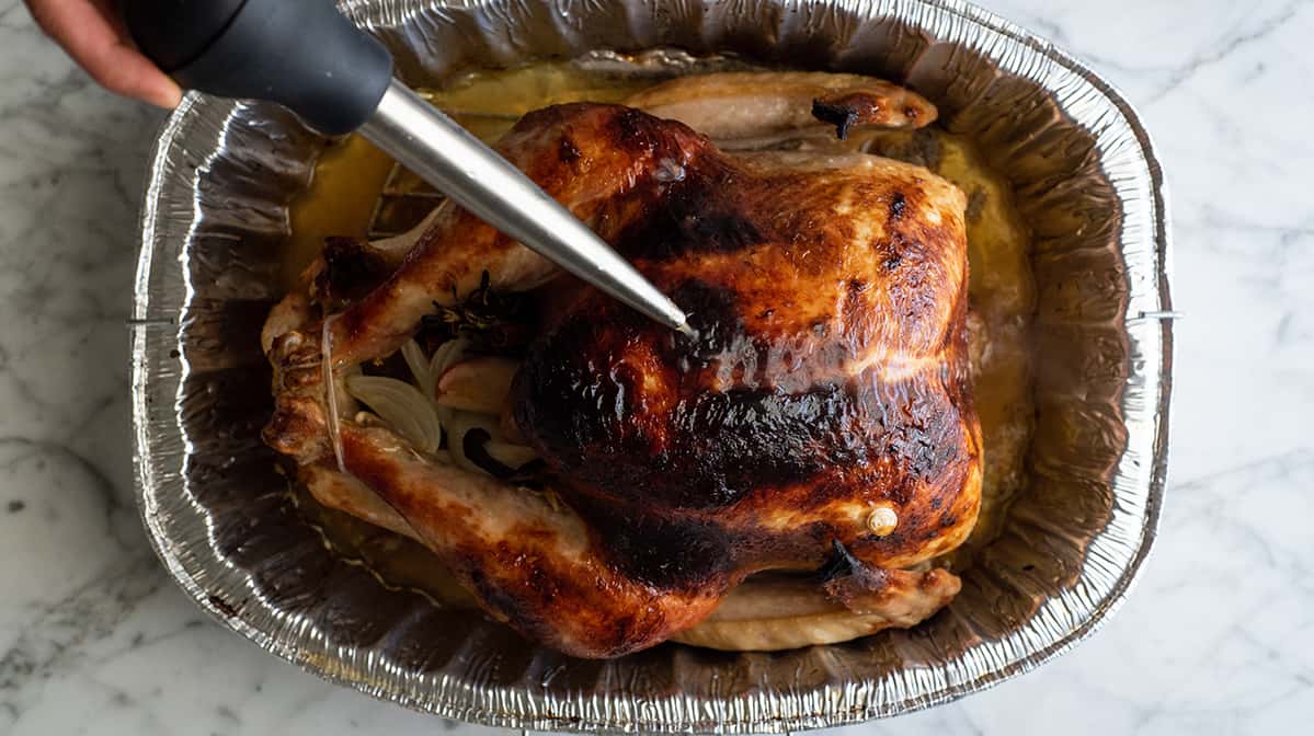 overhead photo showing how to cook a turkey - basting