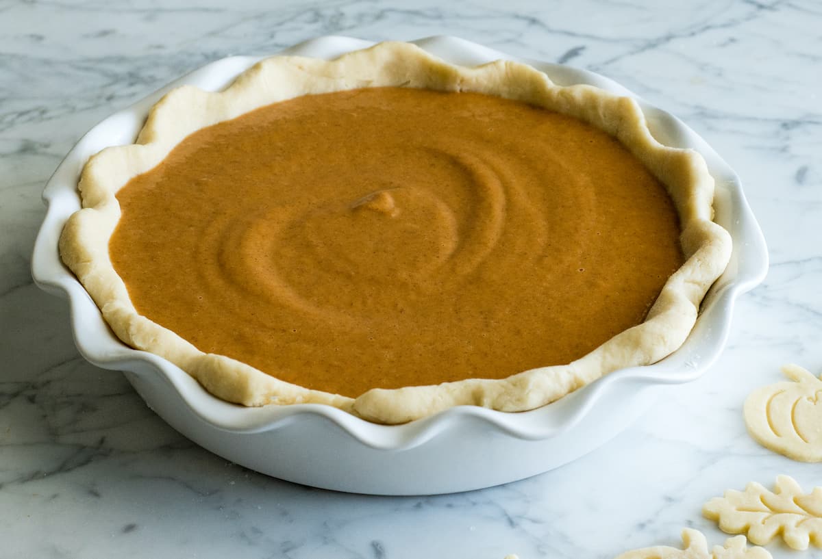 front view of the best pumpkin pie recipe in a white pie dish before baking 