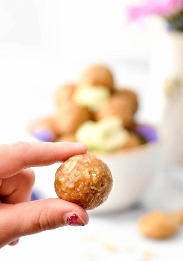 Up close front view of a kid's hand holding one Peanut Butter Oatmeal Balls