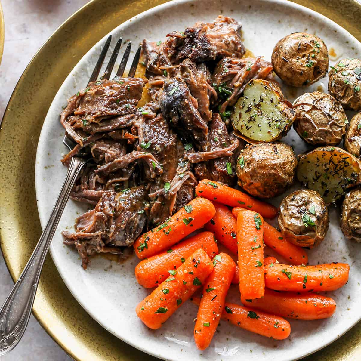 Slow Cooker Pot Roast on a plate with carrots and potatoes