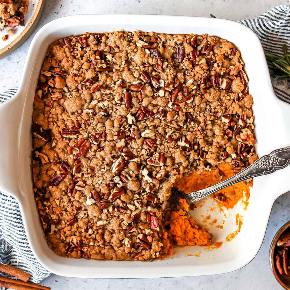 overhead view of sweet potato casserole with pecans in a baking dish